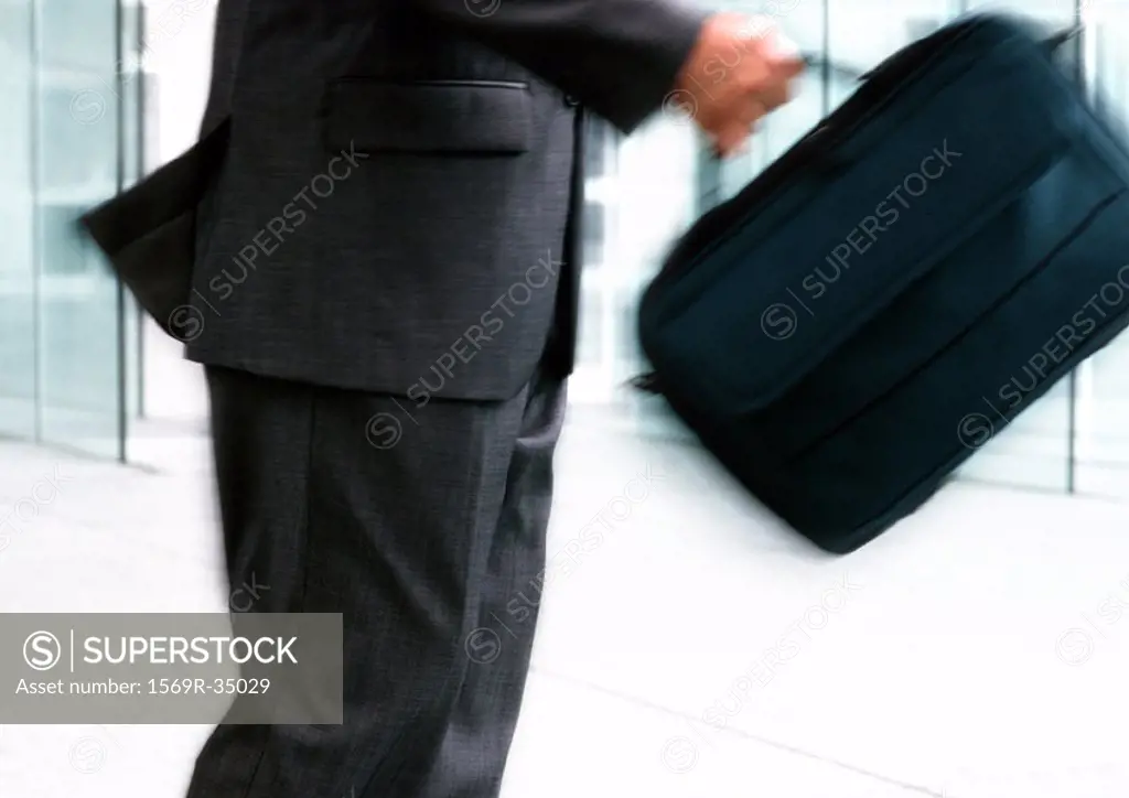 Man holding bag, mid section, blurred motion