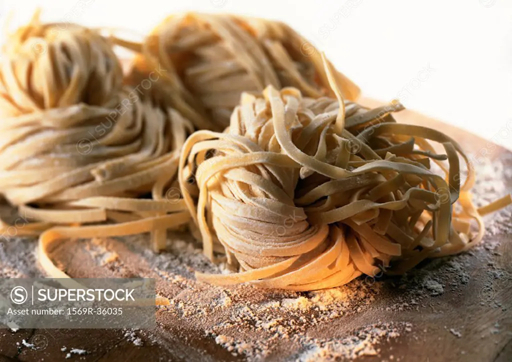 Mounds of fresh pasta on floured board, close-up
