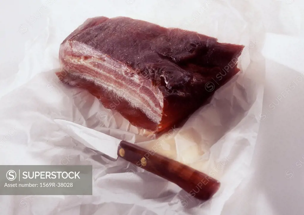 Slab of smoked bacon and knife, close-up