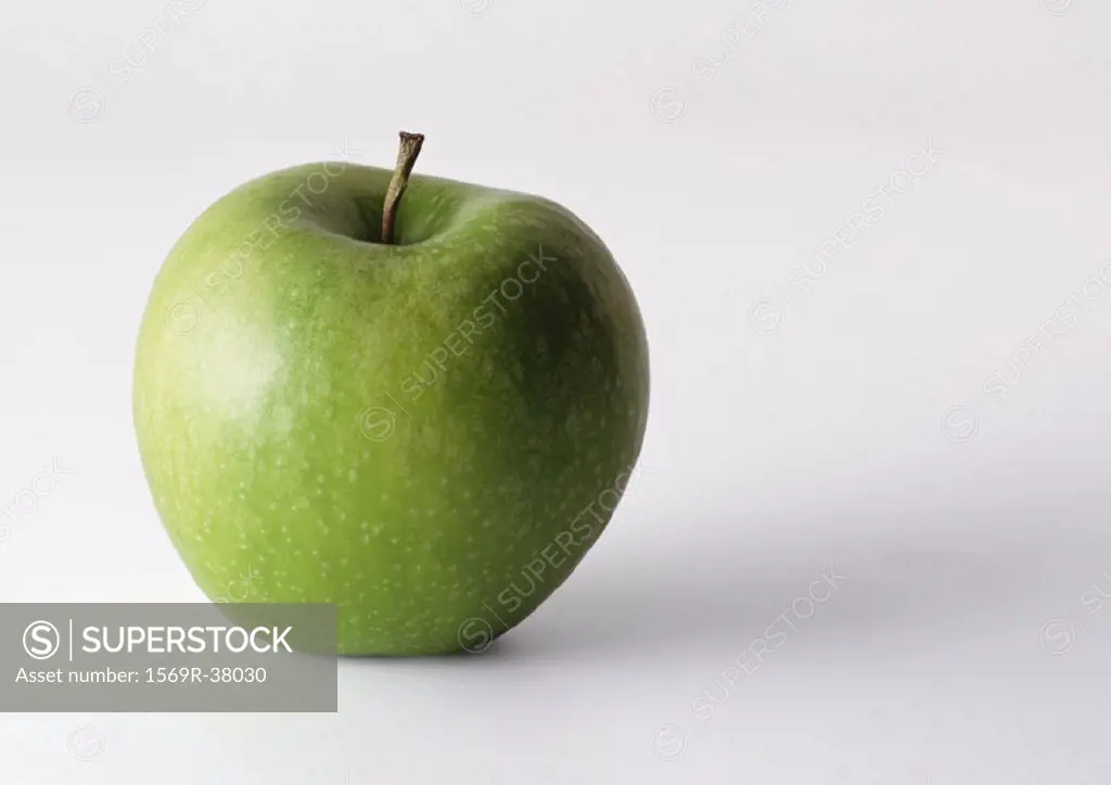 Green apple with stem, in upright position, closeup, white background