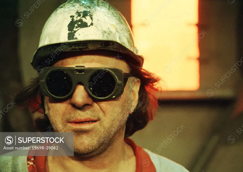 Man wearing hard hat and protective glasses, portrait