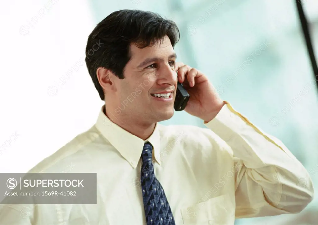 Businessman using cell phone, portrait