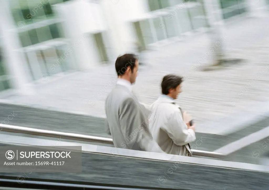 Two businessmen on stairs outside, blurred