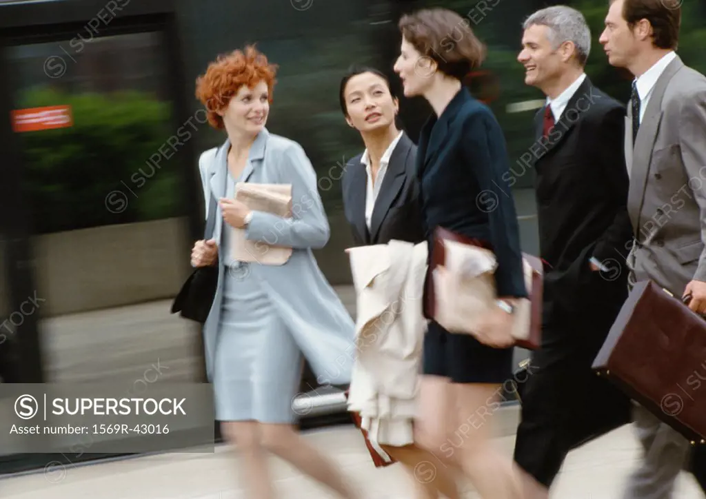 Group of business people walking side by side, blurred