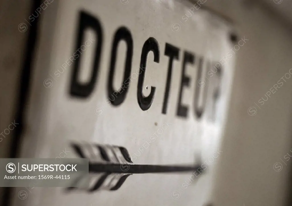 ´Doctor´ text in French on sign with arrow, close-up
