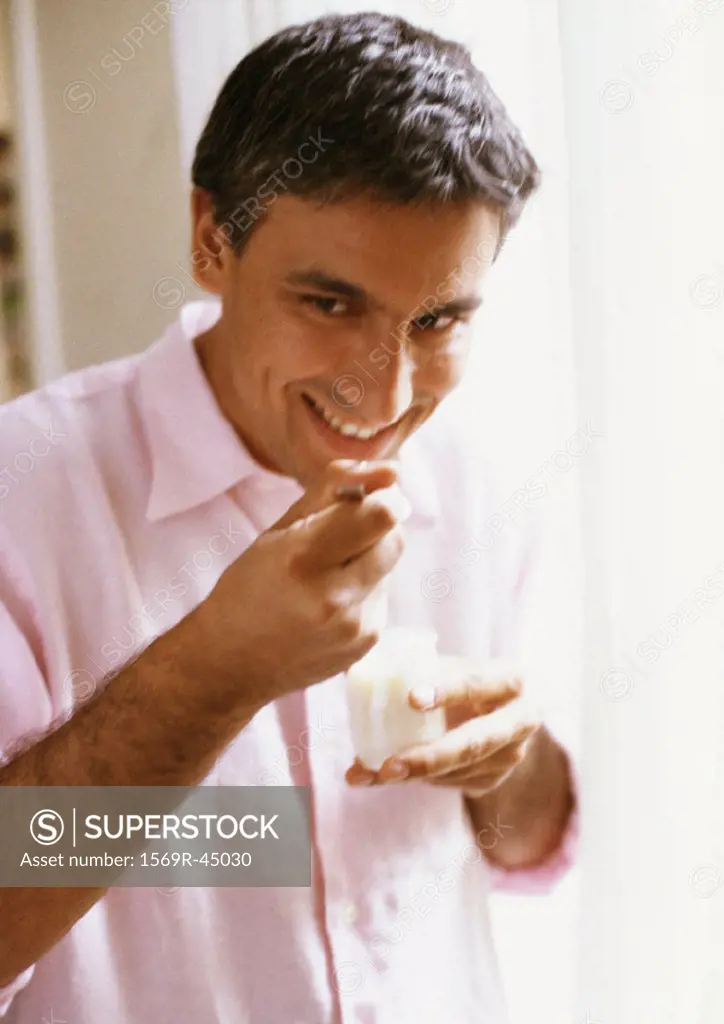 Man eating yogurt, portrait, blurred