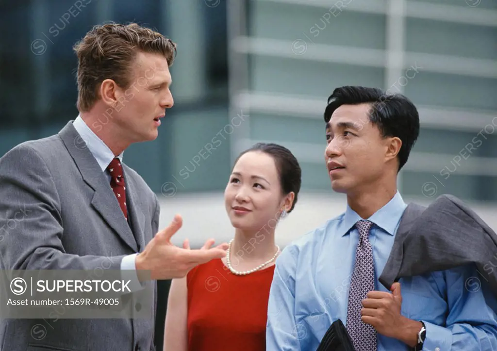 Two men and a woman, one gesturing with hand