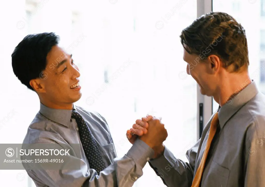 Two men shaking hands, side view