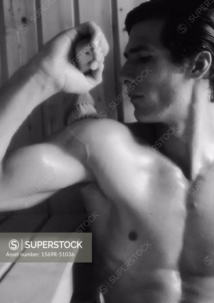 Man brushing back in sauna, close-up, b&w