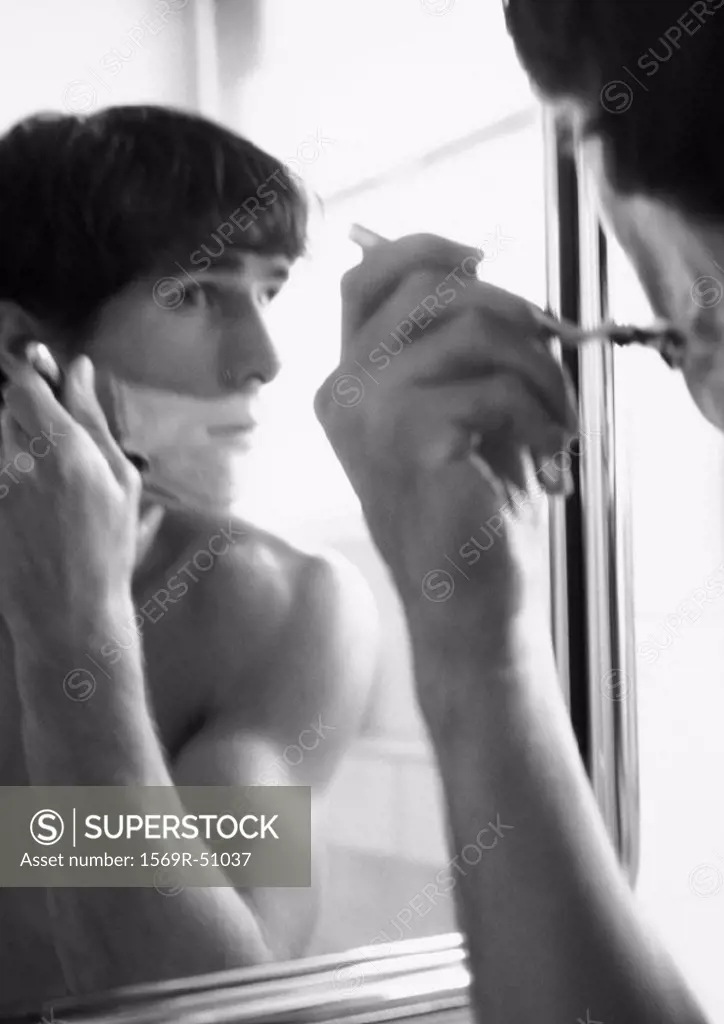 Man shaving in mirror, b&w