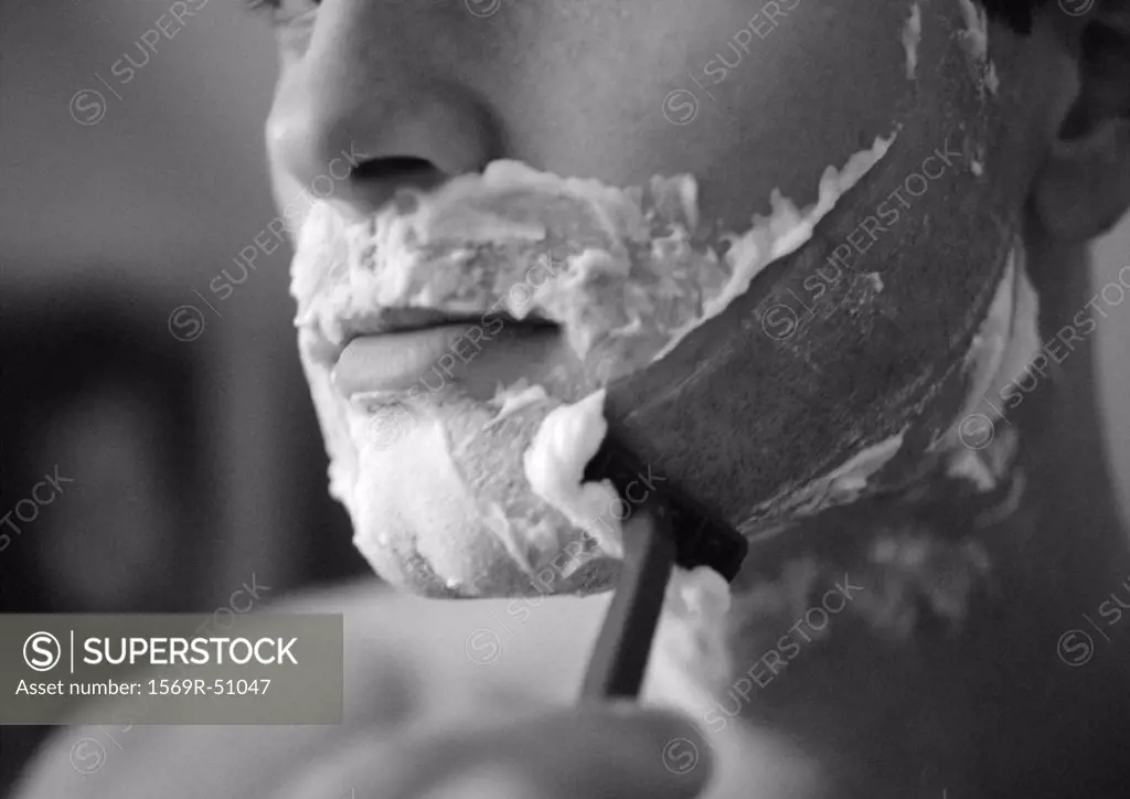 Man shaving, close-up, b&w