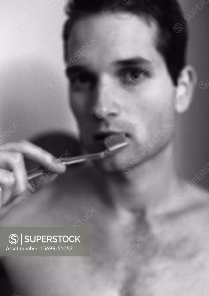 Man brushing teeth, blurred, portrait, b&w