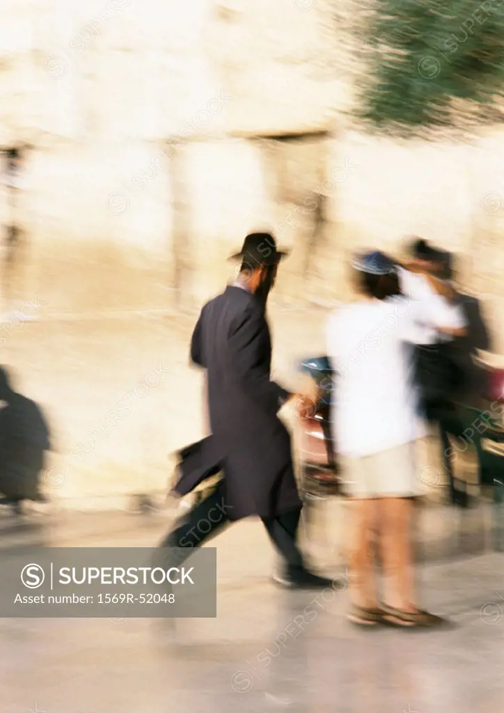 Israel, Jerusalem, Orthodox Jew running in street, blurred