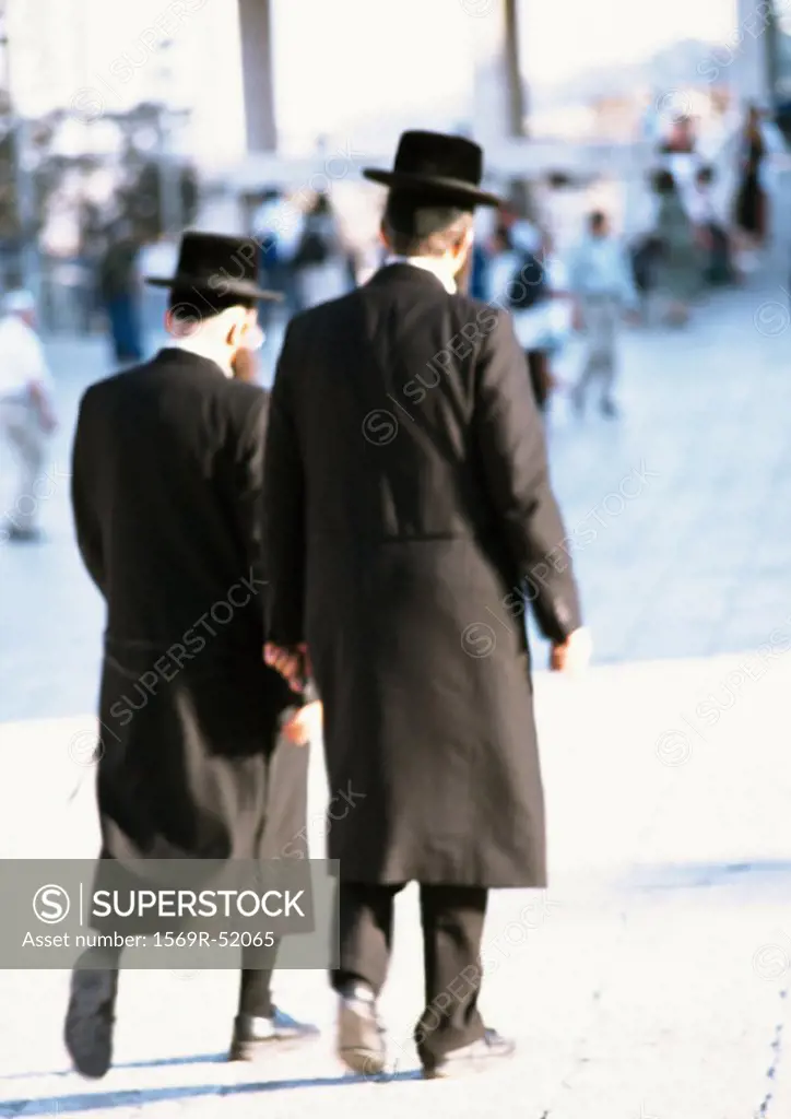 Israel, Jerusalem, Orthodox Jews walking in street, rear view