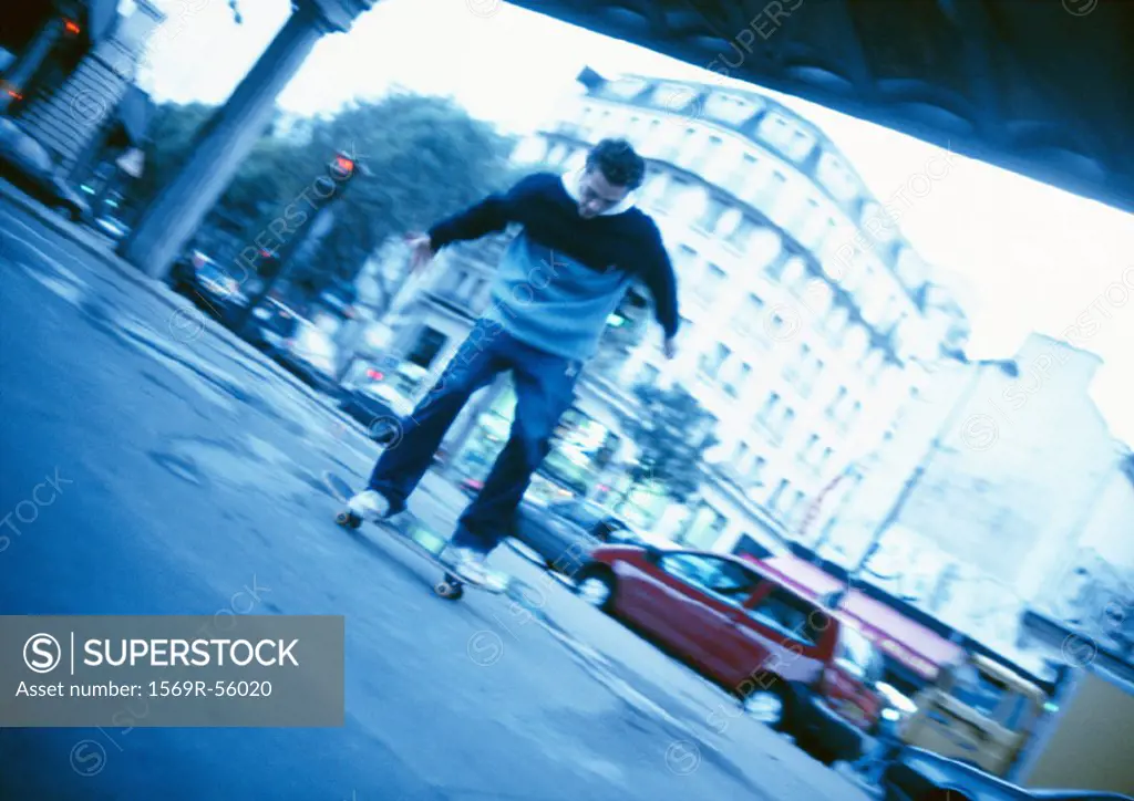 Young man skateboarding in street
