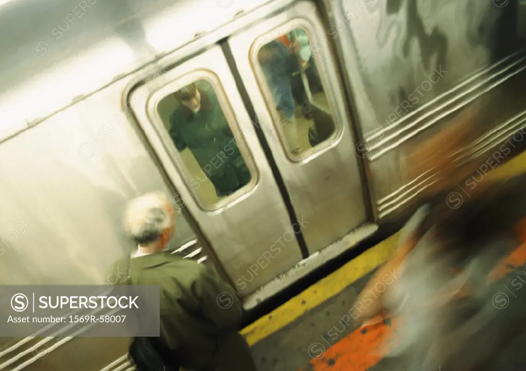 Person waiting in front of subway doors, high angle view, blurred