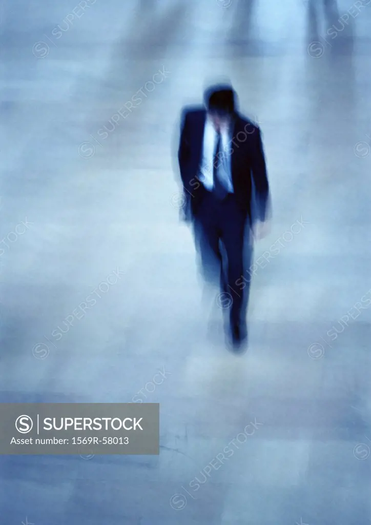 Businessman walking, high angle view, blurred