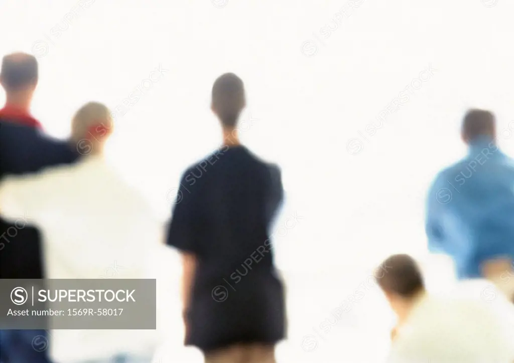 People standing side by side, rear view, blurred