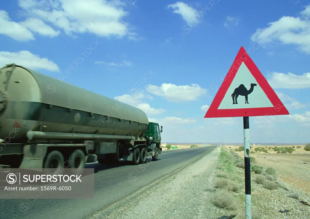 Jordan, tanker on road next to camel crossing sign