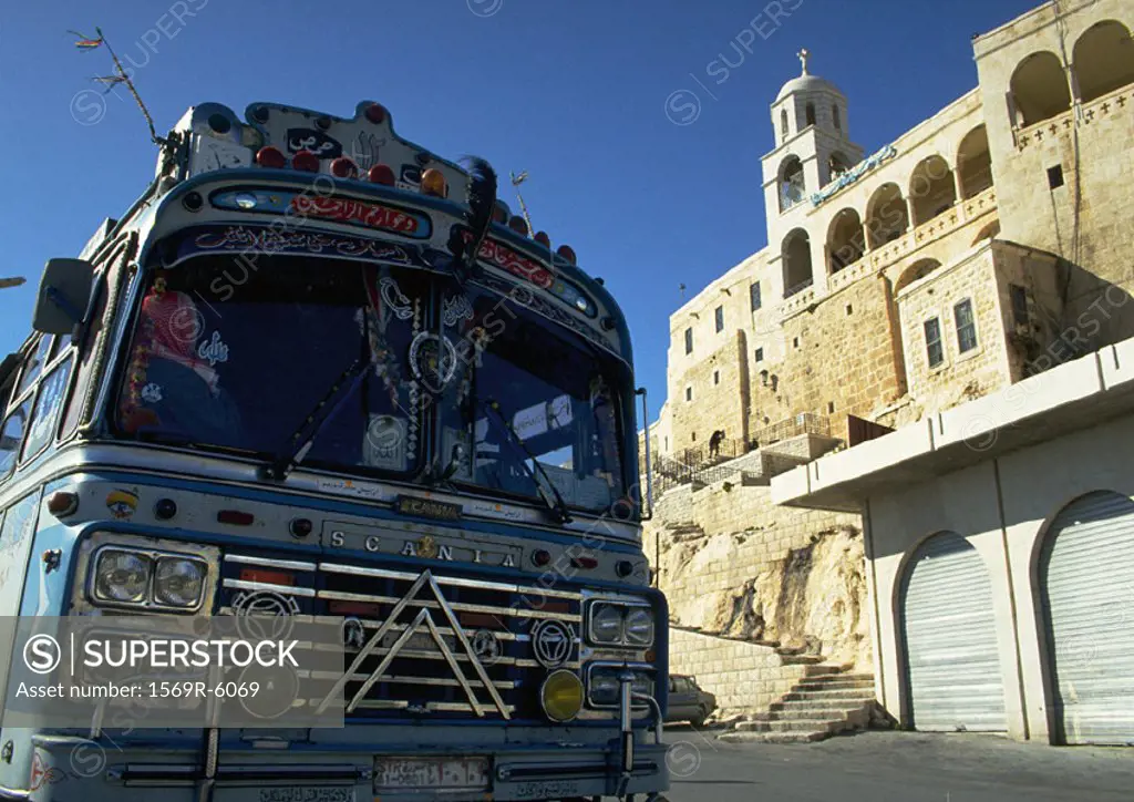 Syria, front of blue bus and ancient building