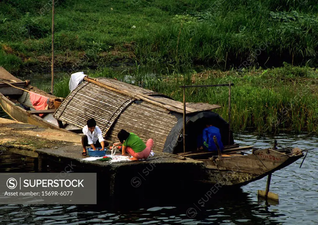 Vietnam, people on dock next to houseboat