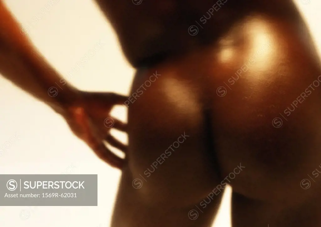 Man´s bare buttocks and hand, close up, blurred