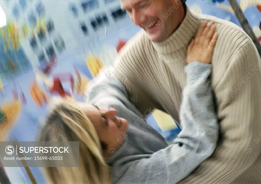 Man and woman holding each other, blurred