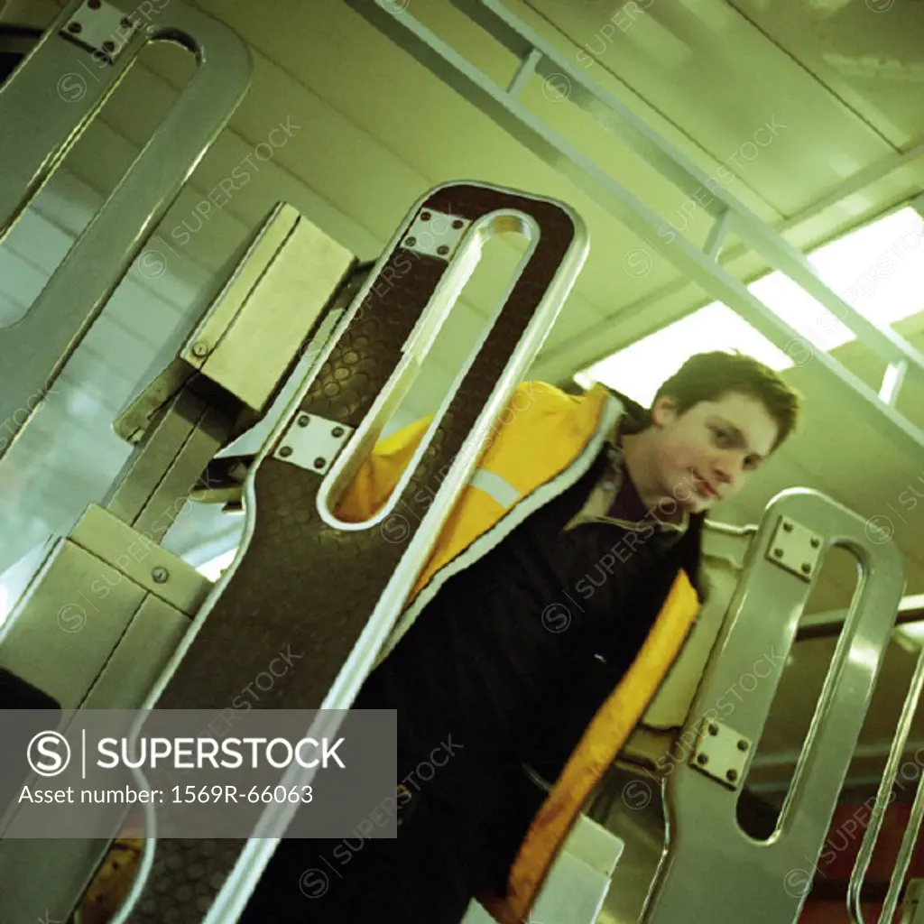 Young man walking through turnstile gate in subway