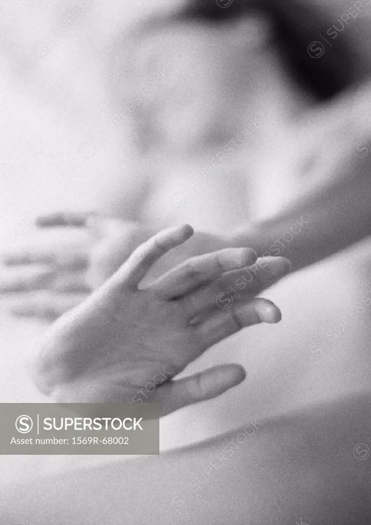 Nude woman holding hands out, close-up of hands, black and white