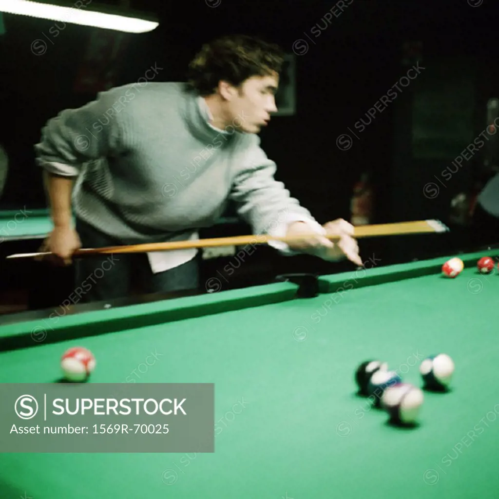 Young man shooting pool