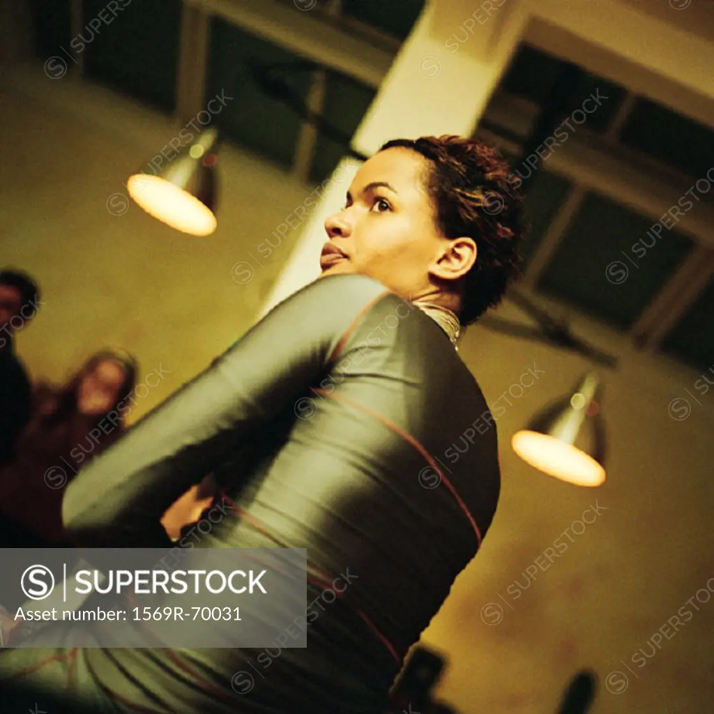 Teenage girl sitting with arms crossed, low angle view