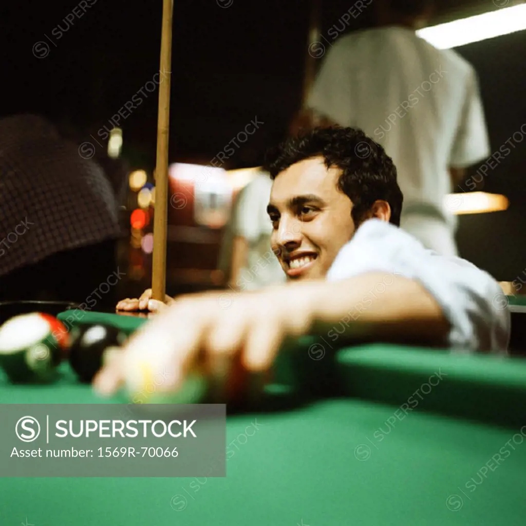 Young man retrieving balls from pool table