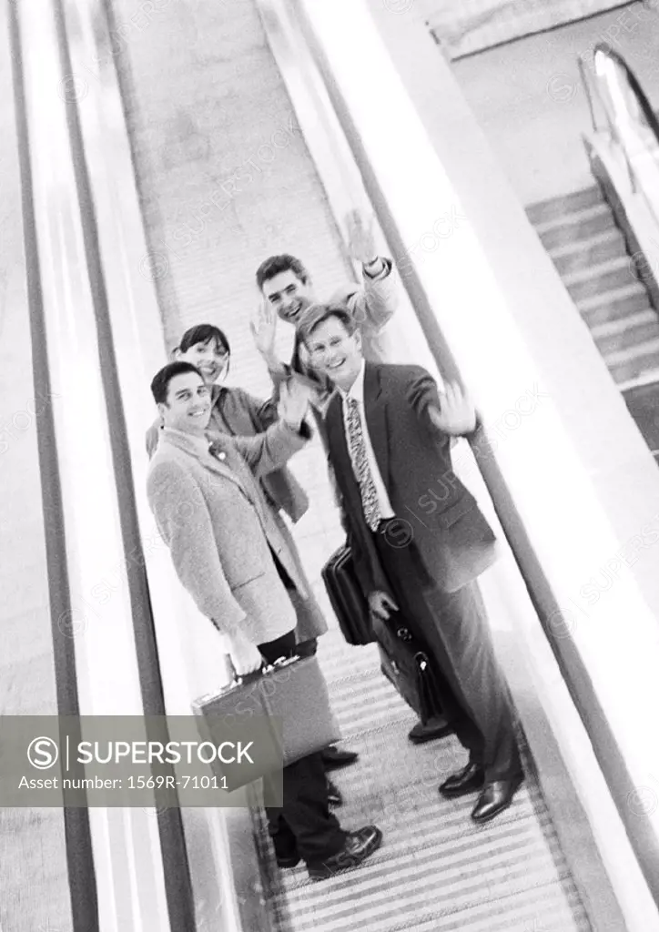 Group of business people waving at camera, blurred, b&w