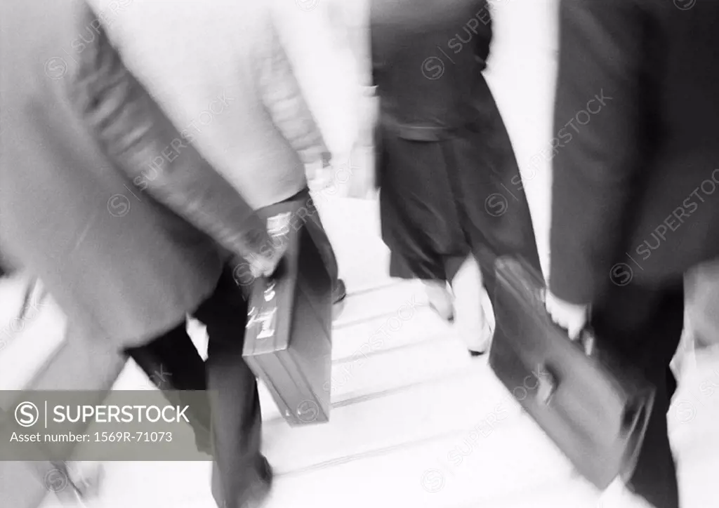 Business people walking down steps, lower section, blurred, b&w