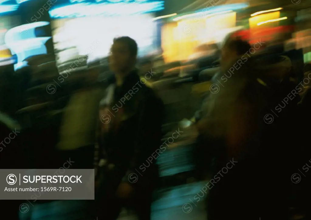 France, Paris, people in street at night, blurred