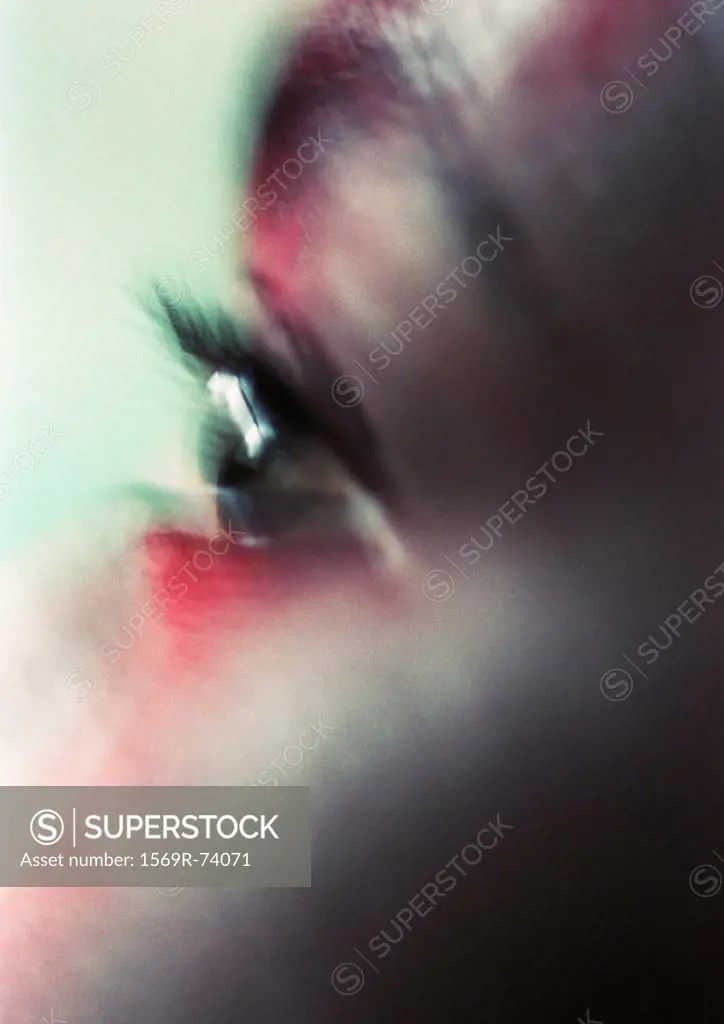 Woman´s eye with red make-up on face, close-up, blurred