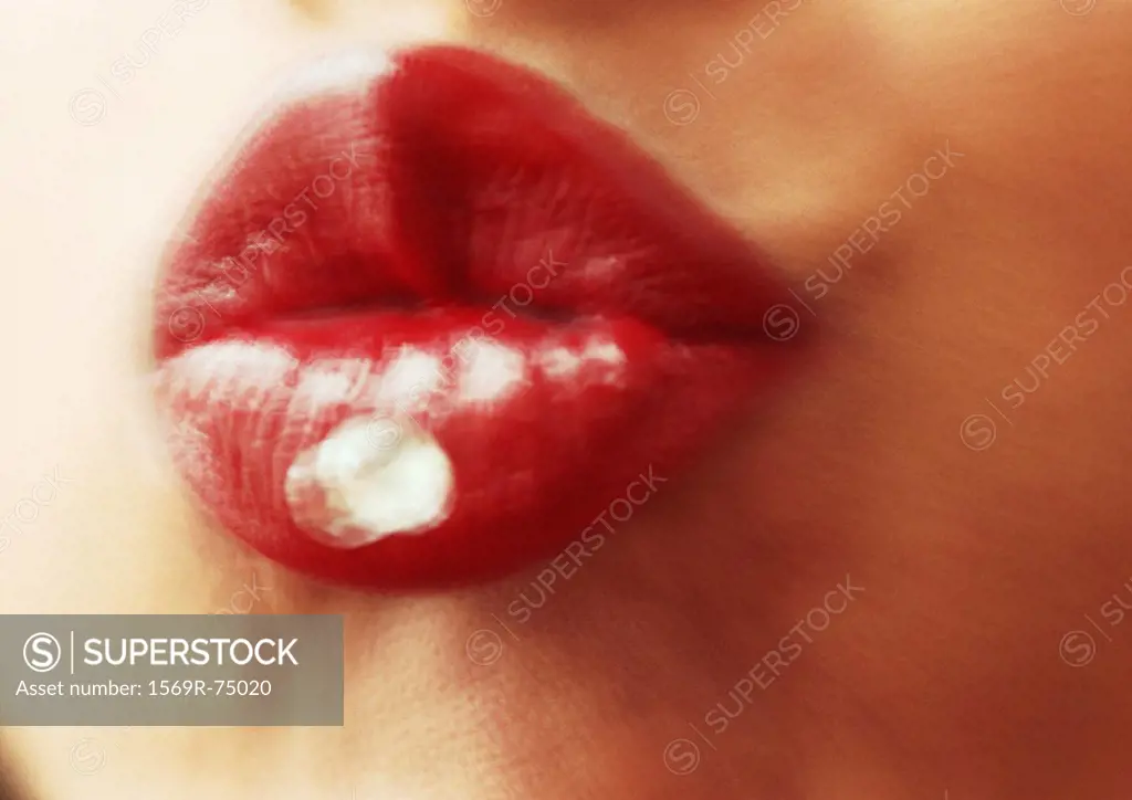 Woman wearing red lipstick, close up of puckered lips, blurred