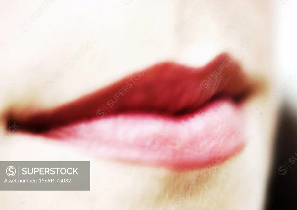 Woman wearing red lipstick, close up of mouth, blurred