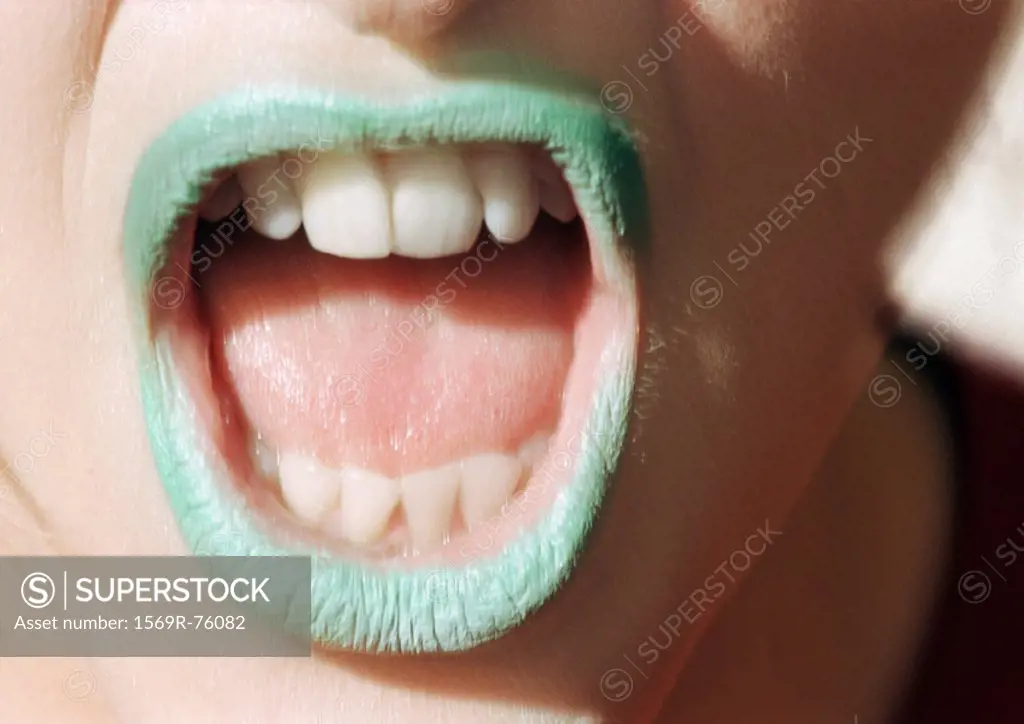 Close up of woman´s mouth open with green lipstick