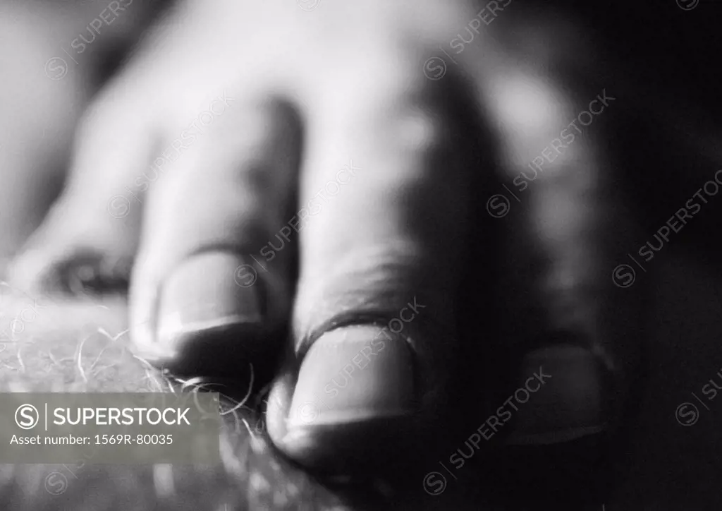 Man´s fingers on leg, close-up black and white