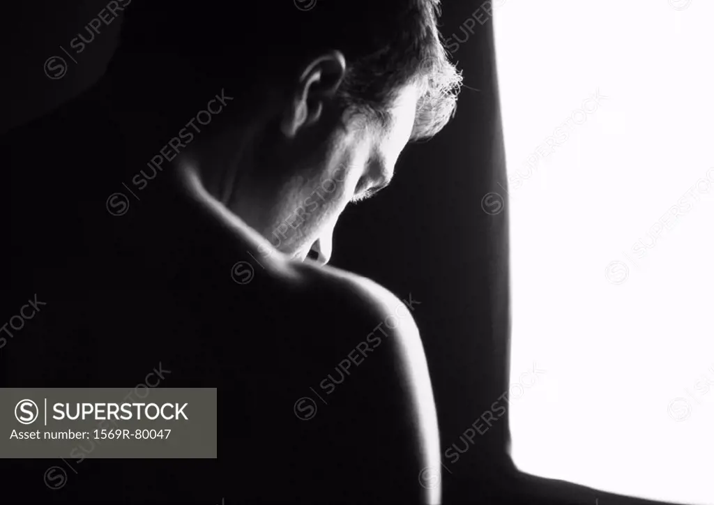 Nude man looking down, rear view, close-up, silhouette, black and white
