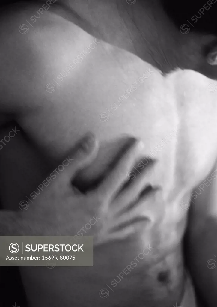Nude man touching chest, blurred, close-up, black and white