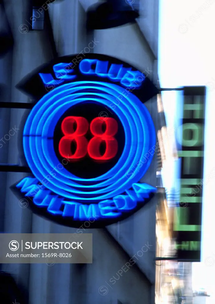 ´Le Club Multimedia´ neon sign with ´Hotel´ sign in background, blurred