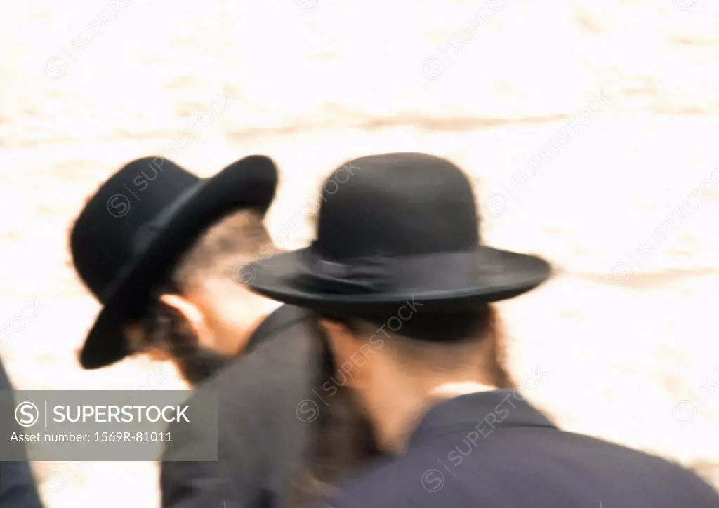 Israel, Jerusalem, Orthodox Jewish men praying at Wailing Wall, rear view, blurred