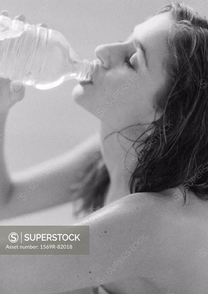 Woman drinking from water bottle, close-up, B&W