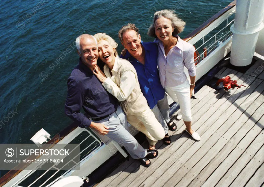 Mature couples standing next to railing of boat, looking at camera, portrait, high angle view