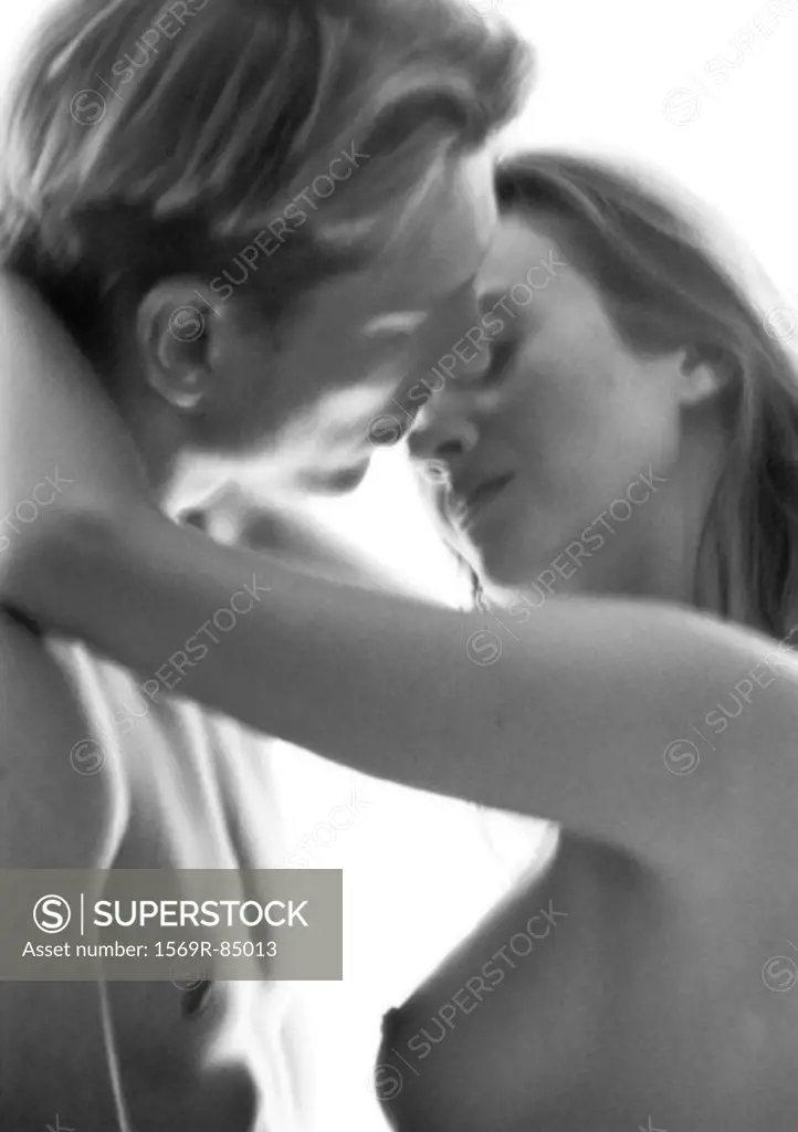 Nude male and female embracing, kissing, blurred black and white