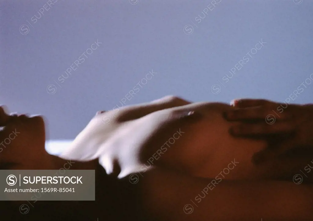 Man´s hand on nude woman´s chest, blurred