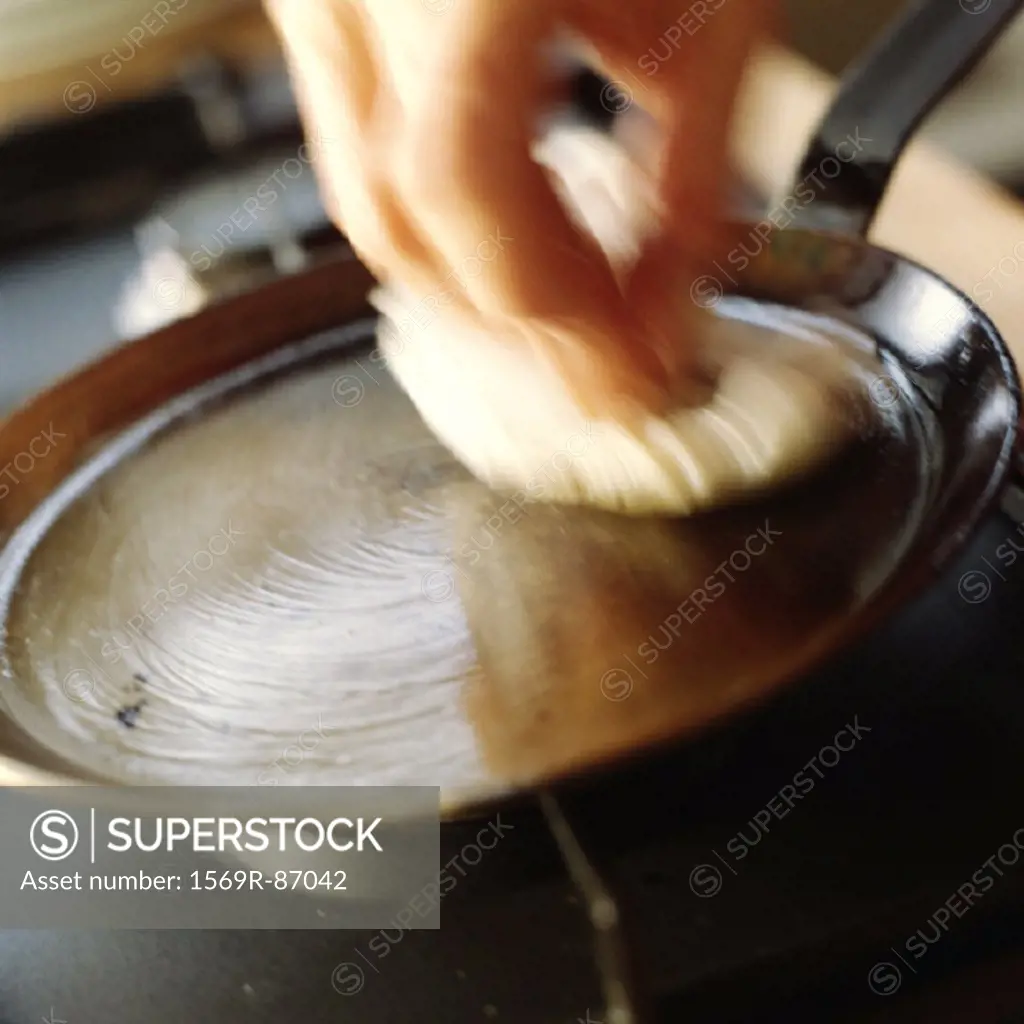 Close-up of a pan being oiled, blurry