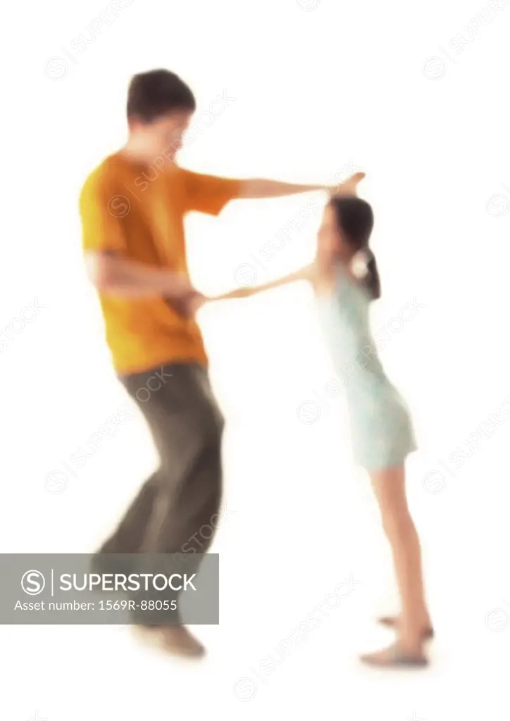 Silhouette of girl and teenage boy dancing, on white background, defocused